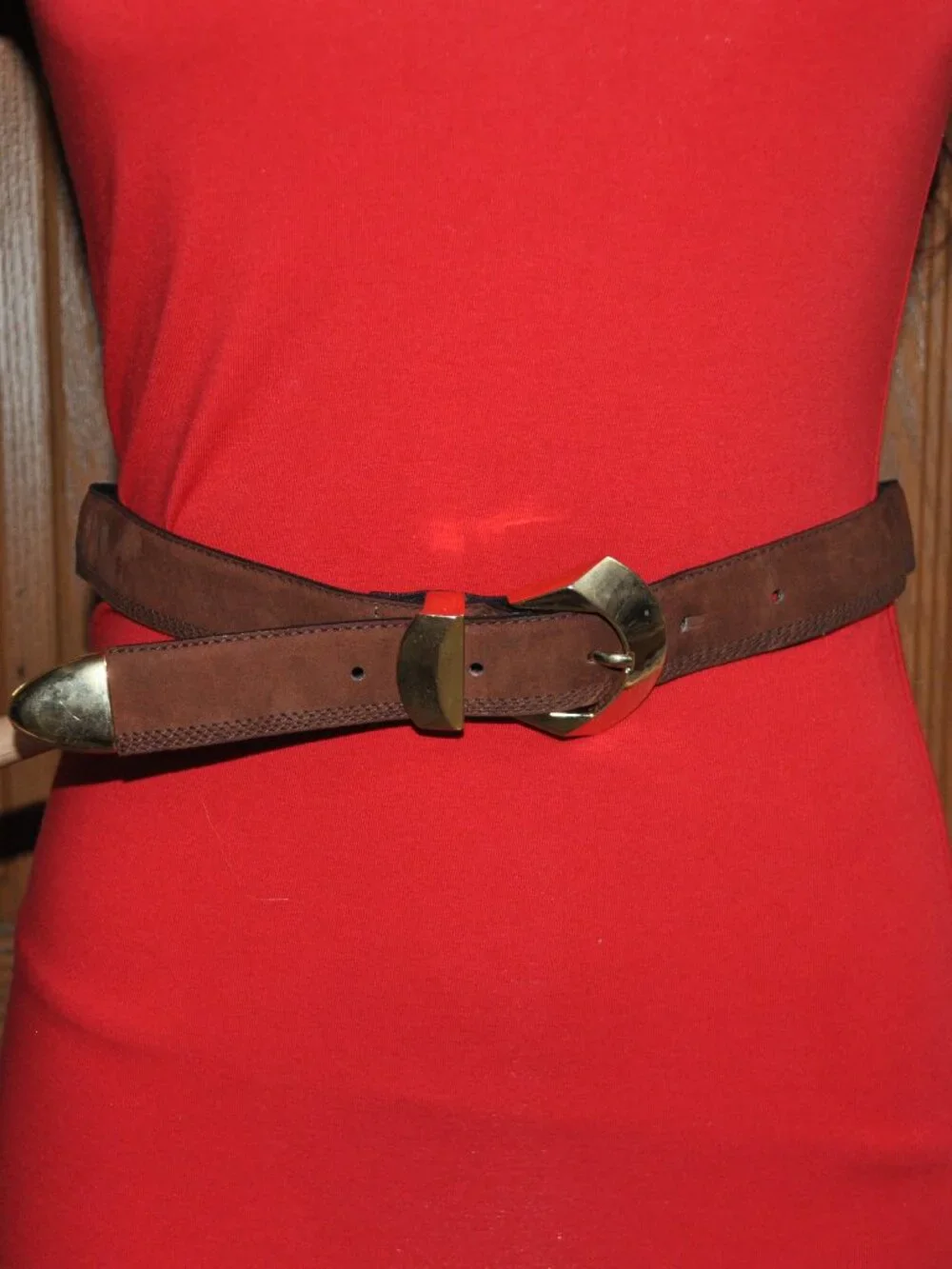 Women's belt features distinctive gold-tone metal hardware, including a unique